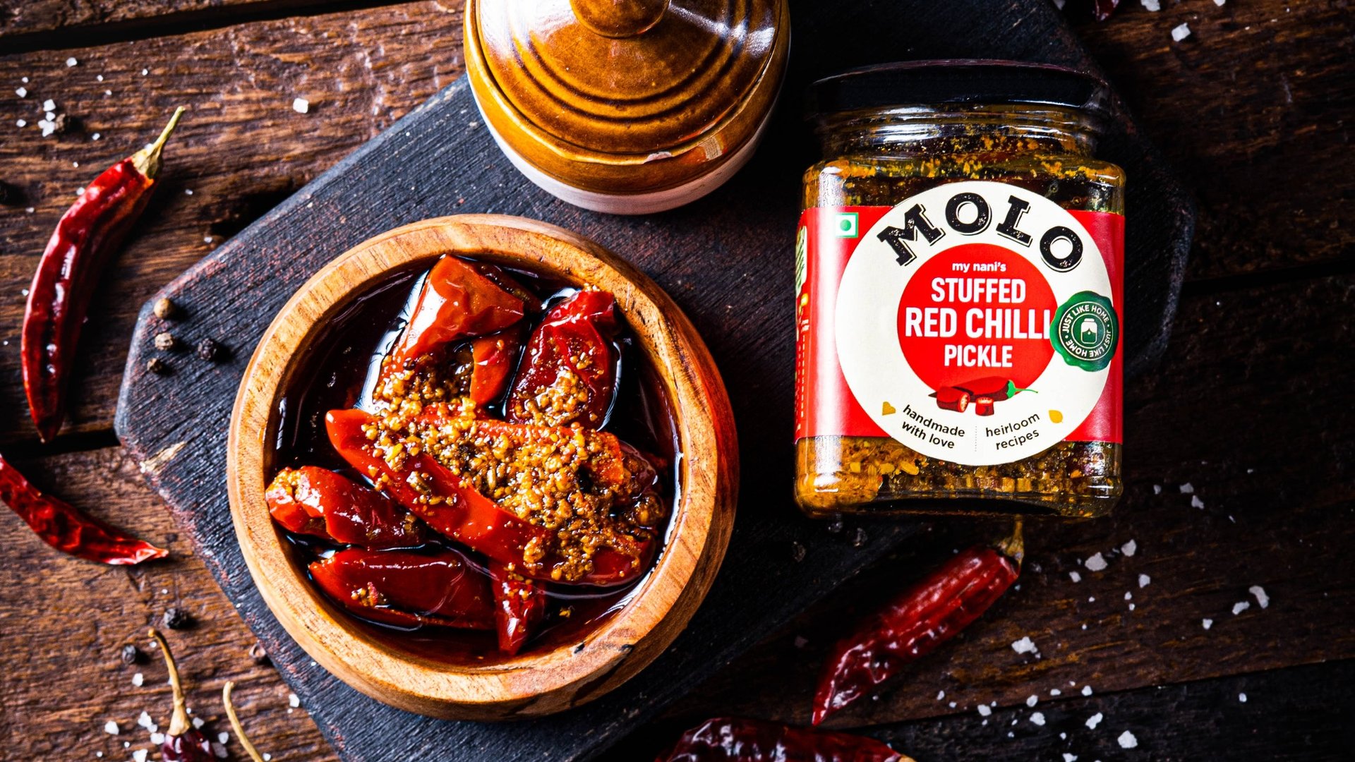 Molo Foods — Stuffed Red Chilli Pickle on rustic wooden table